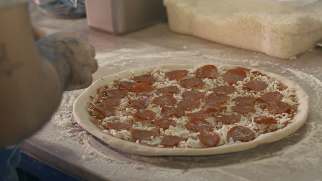 Pizzaiolo montando pizza no balcão