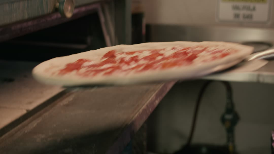 Pizza entrando no forno a lenha na pá